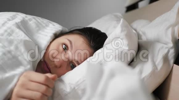 流鼻涕的女人躺在床上她从盒子里拿出纸巾在里面吹鼻子感冒流感过敏灰尘视频的预览图