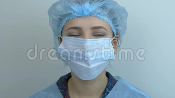 快乐微笑的女科学家在冠状病毒大流行后摘下保护性医疗面罩年轻的白种人妇女被驱逐视频的预览图
