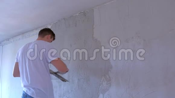 泥工正在用抹刀在墙上涂上湿灰使墙对齐视频的预览图
