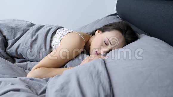 女人躺在床上微笑肖像年轻的女性脸微笑着对着镜头近距离观看穿内衣的害羞少女撒谎视频的预览图