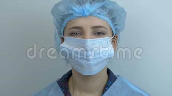 微笑女医生摘下医用面罩的肖像特写幸福的年轻女子在视频的预览图