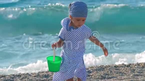 可爱的严肃的小女孩在沙滩上玩耍视频的预览图