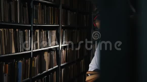 图书馆里的一个少年晚上读一本书视频的预览图
