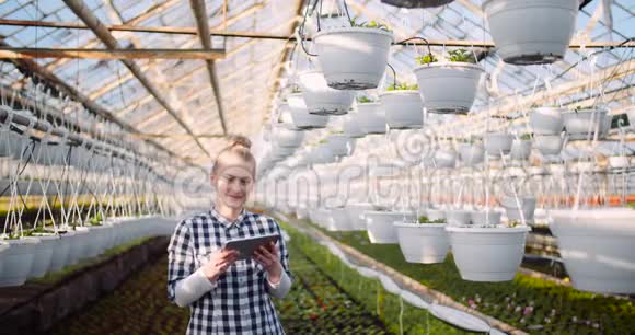 园丁在温室里使用数码平板电脑微笑视频的预览图