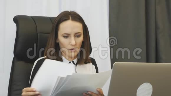 震惊女老板看财务报告忧心忡忡的女商人看着公司的账户令人不安的女人看着报道视频的预览图