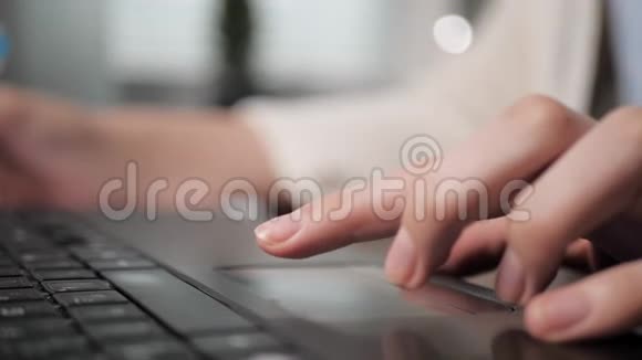 左女性手移动手指穿过笔记本电脑触摸板并按下右触摸板按钮工作或学习的女孩视频的预览图