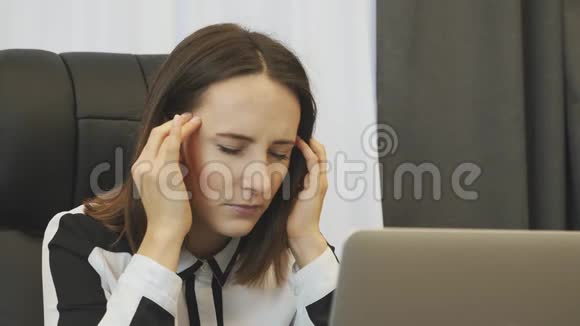 女商人因在办公室工作而感到压力疲惫的女老板在办公室工作时双手抱头年轻的时候视频的预览图