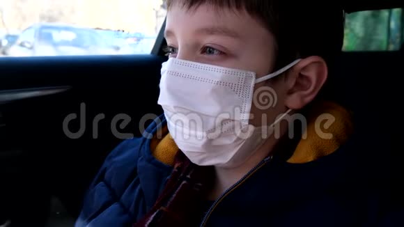一个十几岁的男孩坐在车里戴着白色外科口罩以防病毒冠状病毒视频的预览图