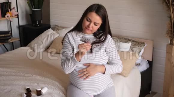 一个怀孕的女孩仔细研究药片上的说明视频的预览图