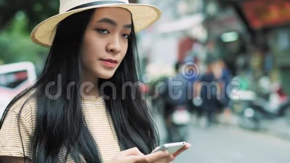 年轻的越南女人带着手机等待出租车视频的预览图