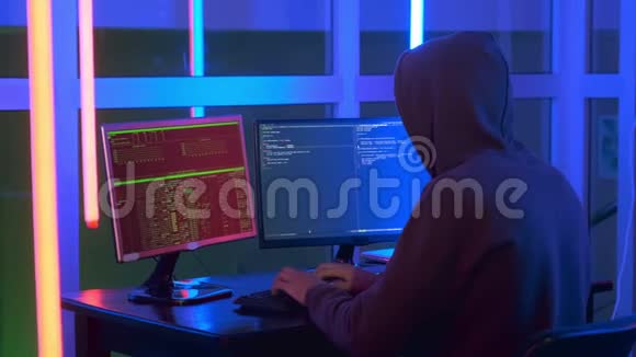 中型黑客穿着黑色紧身衣在电脑上工作视频的预览图