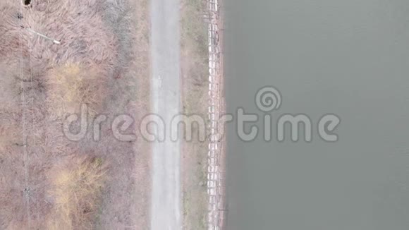 沿坝空隔行人路鸟瞰带河的旅游步道沿湖的窄路无人机射击视频的预览图