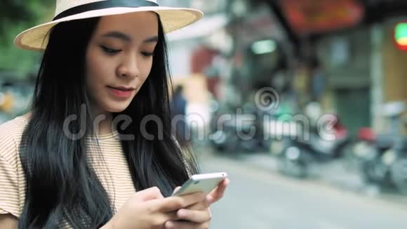 关闭年轻的越南妇女使用智能手机在城市视频的预览图