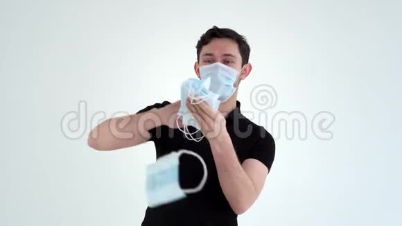年轻兴奋的男人戴着防护面具扔医疗面具视频的预览图