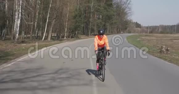 女三项运动员骑公路自行车女人骑自行车在空路上骑自行车的女孩自行车和铁人三项运动的概念视频的预览图