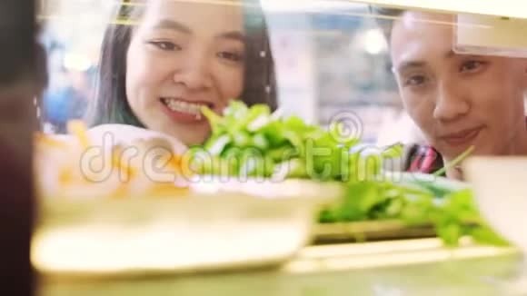 年轻夫妇在餐馆里选择越南菜视频的预览图
