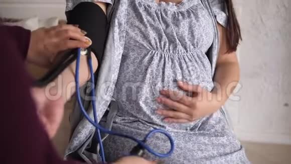 医生检查孕妇床上血压计的血压视频的预览图