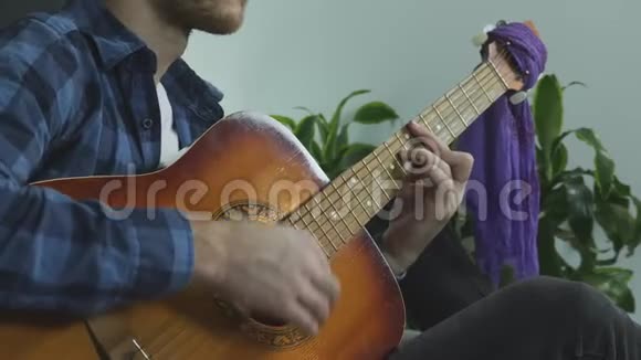 年轻成功的音乐家在家弹吉他练习和作曲视频的预览图