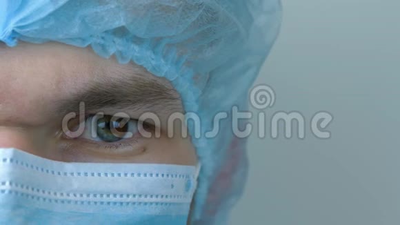 年轻男工戴防护医用面罩特写对Covid19冠状病毒的大流行保护穿着医疗服的男人视频的预览图