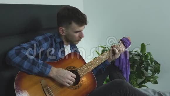 年轻的音乐家吉他手演奏感官慢民谣吉他手指风格在家练习音乐会视频的预览图