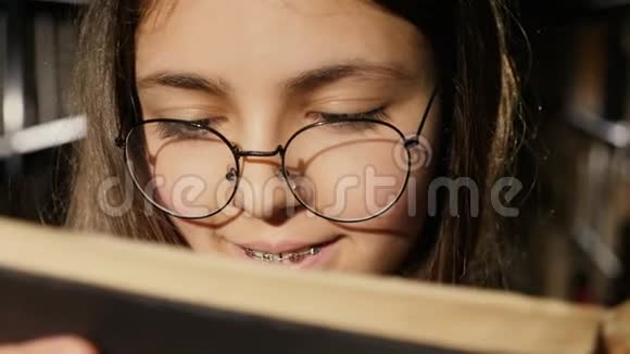戴眼镜的女孩在图书馆看书特写视频的预览图