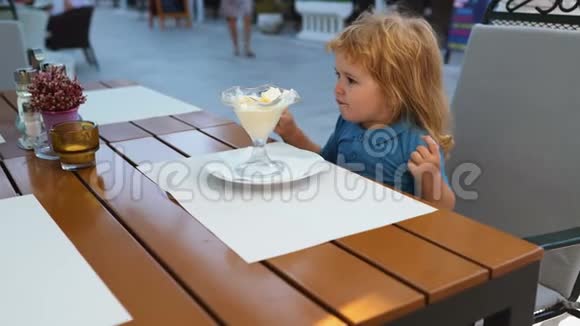幼儿童年儿童幸福观念可爱的学步男孩吃冰淇淋咖啡馆的冰淇淋视频的预览图