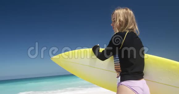 在海滩上拿着冲浪板的女人视频的预览图