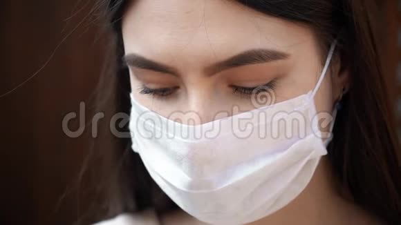 戴着医用面罩的年轻女性看着镜头预防冠状病毒视频的预览图