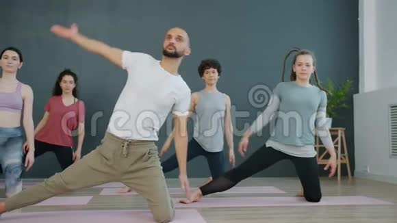 活跃的男人和女人在瑜伽馆做运动伸展身体肌肉视频的预览图