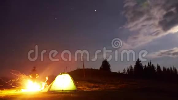父亲和儿子在晚上露营的篝火旁时光流逝视频的预览图
