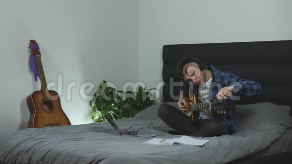 人调谐器电吉他年轻的音乐家在家里调音吉他男性曲调吉他弦吉他课音乐概念视频的预览图