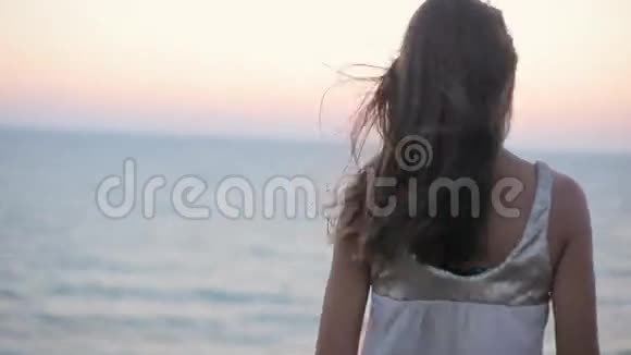 悲伤快乐的女孩在海边的夕阳下祈祷视频的预览图