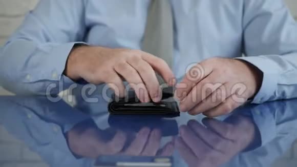 商人从办公桌上取一张信用卡放进钱包里视频的预览图