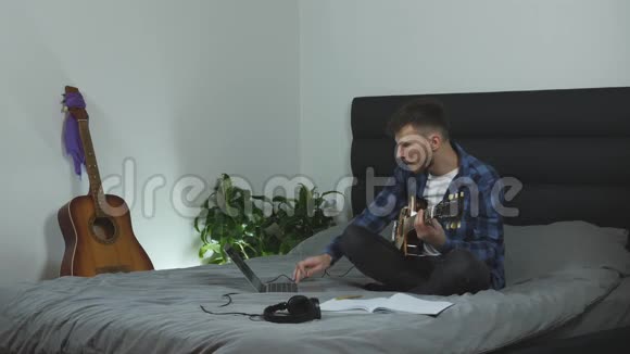 吉他手在家里客厅里学习新歌人弹电吉他千禧一代用吉他演奏他的新歌M视频的预览图