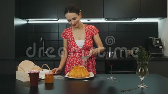 女孩在现代家庭厨房做自制派微笑快乐的家庭主妇准备了烘焙蛋糕年轻的白种人穿着红裙子视频的预览图