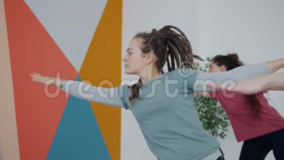 年轻漂亮的女孩臀部做瑜伽体式现代工作室锻炼与团体视频的预览图