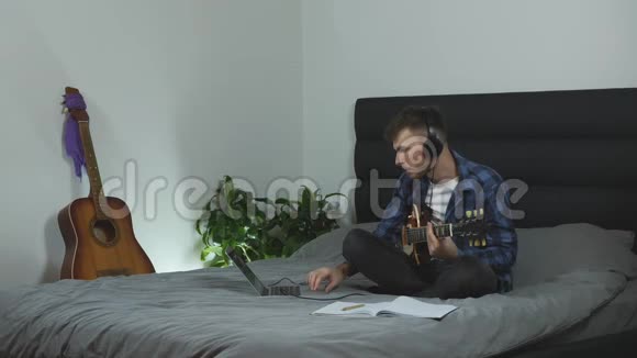 吉他手学习独奏部分年轻有魅力的男人在现代家庭里弹电吉他男性千禧年演奏新歌视频的预览图
