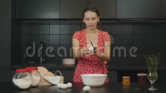 有魅力的家庭主妇在现代厨房把鸡蛋打碎成碗年轻女子在家厨房做饭女厨师打破鸡蛋和c视频的预览图