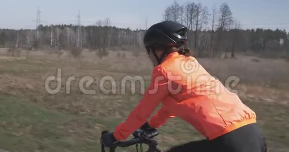 骑自行车的人骑自行车女子三项运动员在自行车上集中骑行女性在空路上骑自行车女孩培训视频的预览图