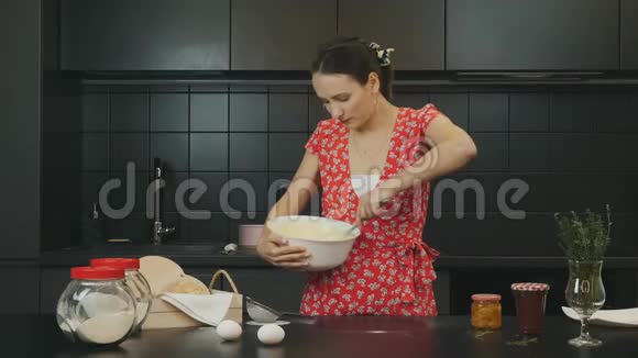 现代职业厨房的年轻美女快乐的家庭主妇做自制蛋糕微笑的成年女孩搅拌面团视频的预览图