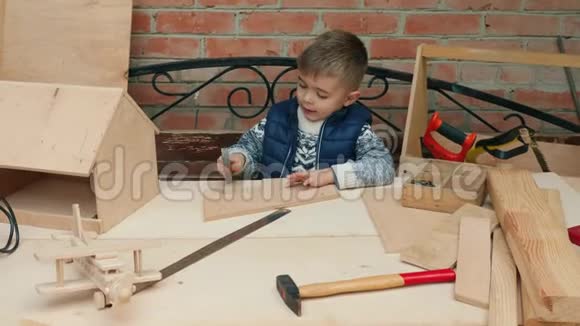小男孩学着把钉子钉在木板上视频的预览图