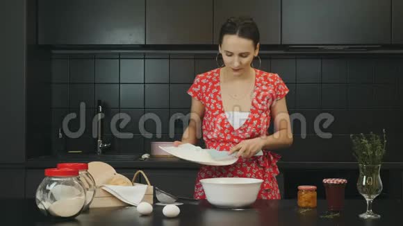 有魅力的女人在现代厨房里做自制饼干年轻快乐的女性将蛋糕的配料混合在专业的包装中视频的预览图