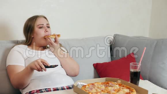 超重女孩吃披萨看电视视频的预览图