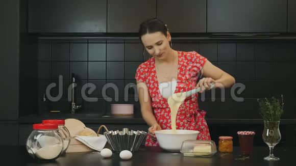 女人在现代厨房做自制派美丽快乐的女性混合饼干原料微笑的家庭主妇在准备视频的预览图