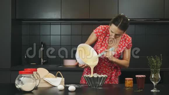 家庭主妇在家里现代厨房里准备馅饼女人把面团倒进烤盘里女厨师自制的甜馅饼家庭厨师视频的预览图