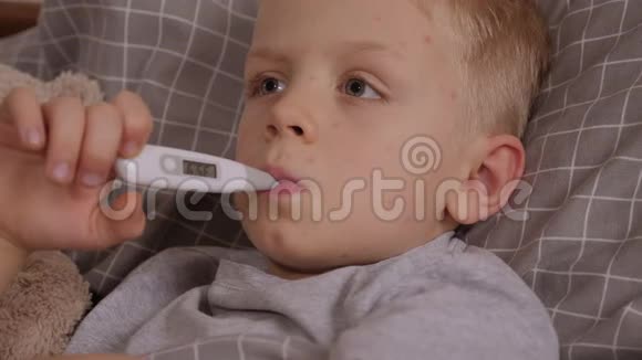 水痘小男孩躺在床上嘴里叼着温度计视频的预览图