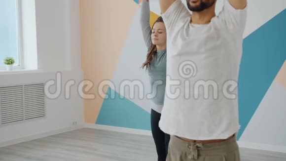 瑜伽专业男女学生在舒适的工作室专注于平衡体位视频的预览图