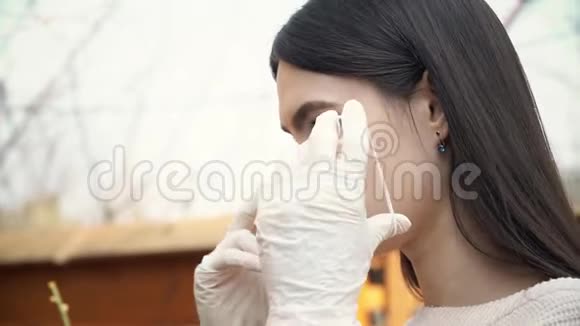 戴防护手套的年轻女子将医用口罩放在外面防止冠状病毒视频的预览图
