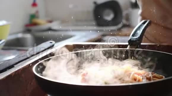 厨师把罗勒叶放在意大利面条上在煎锅里放红色番茄酱视频的预览图