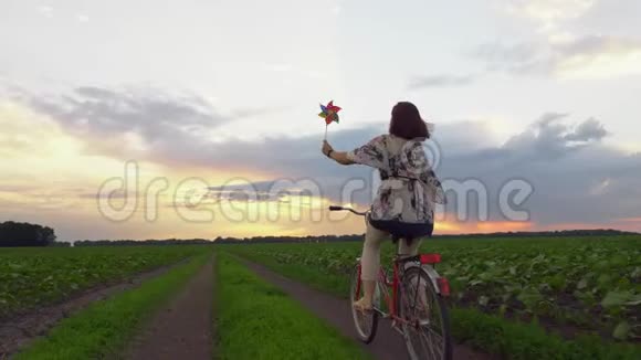 骑自行车的女孩一边拿着风车视频的预览图